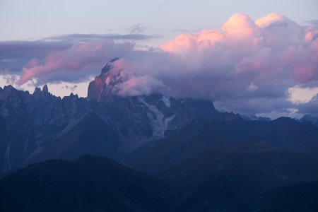Mountain landscape. Peak of the mountain in the clouds. Beautiful sunset with clouds. Mountain Ushba, Caucasus, Georgia, Zemo Svanetiの写真素材