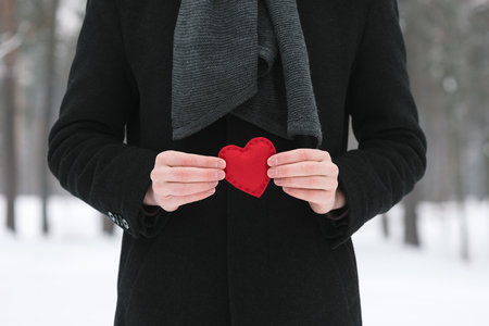 Valentines Day. Man holding a red decorative heartの写真素材