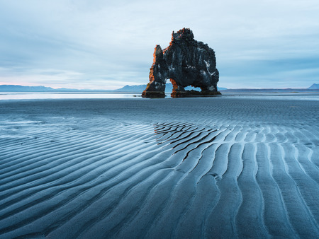 Landscape with a rock in the ocean. Beautiful lines in the sand at low tide. Tourist attraction. Hvitserkur, Iceland, Europeの写真素材