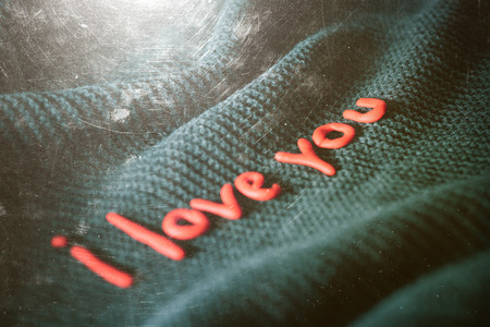 Confession of Love. Phrase of red letters on black fabric. Color toning. The effect of old photos...