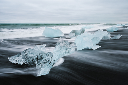 Icy beach in Iceland, Europe. Ice on the black volcanic sand on the Atlantic Ocean. Tourist...