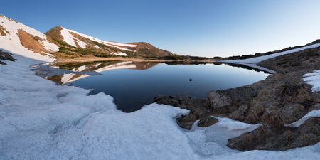 Mountain Lake in the spring. Mountain landscape in the morning. The last snow on the hills. Reflection of the sky in water. Carpathians, Ukraine, Europeの写真素材