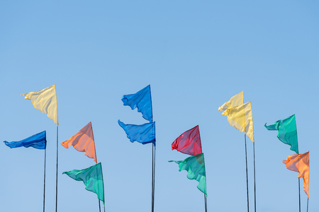 Flags of different colors against the blue sky. Festive backgroundの写真素材
