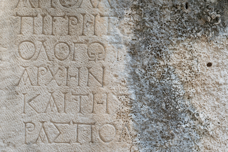 Antique inscription on a stone wall. Historic landmark in the old, ruined city of Faselis, Turkeyの写真素材
