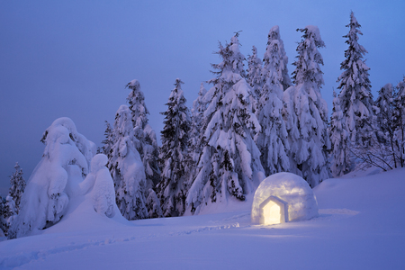 Snow igloo. Mountain hiking in the winter. Evening Landscape with shelter for extreme tourists....