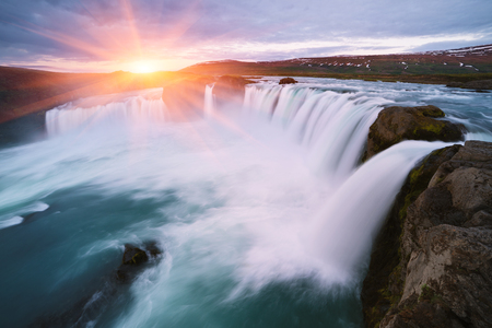 Godafoss waterfall. Natural and tourist attraction of Iceland. Rising sun over the cascade and hillsの写真素材