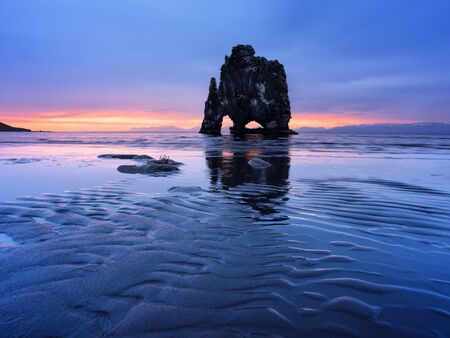 Hvitserkur cliff on the ocean coast in Iceland. Beautiful landscape with the ebb of the water and views of the rising sunの写真素材