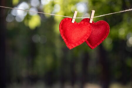 Valentine's Day card with a pair of red hearts against a green backgroundの写真素材