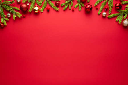 Christmas or New Year red background with fir decor. Blank for advertising text with copy space. Top view, flat layの写真素材