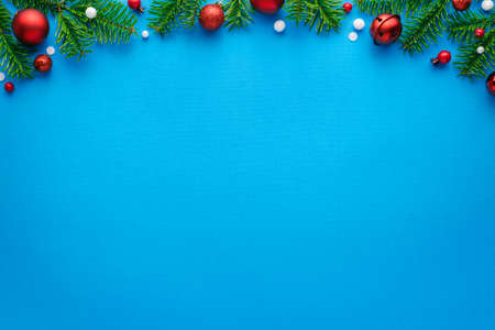 Christmas card with fir decorations on a blue background. Top view with copy space for festive textの写真素材