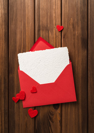 Valentines Day background with greeting card template in envelope on a vintage wood table and red heartsの写真素材