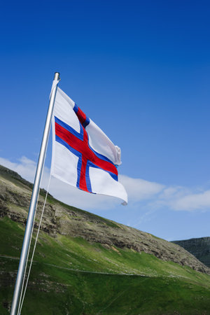 Faroe Islands flag on a blue sky background on a sunny dayの写真素材