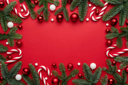 Christmas ornaments Frame with fir branches on a red background. Flat lay, top view and copy space for textの写真素材