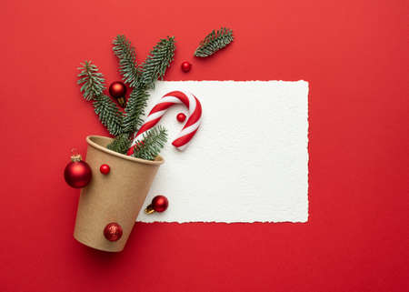 Christmas card with frame on red background and Christmas decorations. Flat lay, top view and copy space for textの写真素材