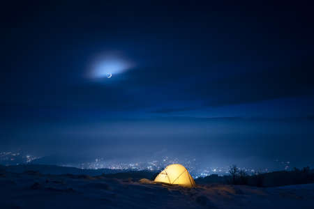 Night winter view with tent in snowy mountainsの写真素材