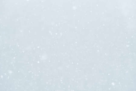 Abstract light winter background with falling snowの写真素材