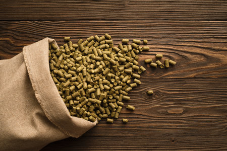 Granules of brewing hops in a bag on a wooden backgroundの写真素材