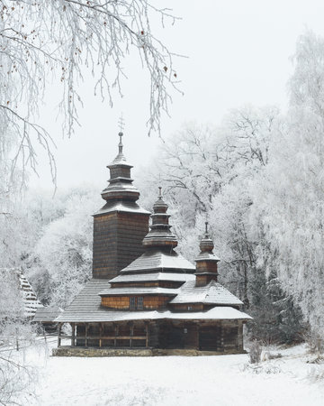 Old wooden church in Museum of Folk Architecture of Ukraine, Kyiv. Fairytale winter landscapeのeditorial素材