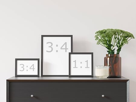 Three empty frames on white wall with black dresser, green plant in brown glass vase - close up image.の写真素材