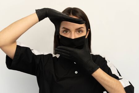 Coronavirus, a young girl in a black protective mask and black gloves, dressed in black clothesの写真素材