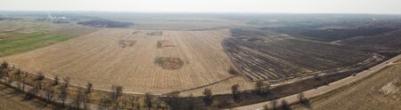 Panorama. Forest and field fire. Dry grass burns, natural disaster. Aerial view. After the fire, the ground is covered with a black layer of burning and ash. Smoke field after wildfireの写真素材