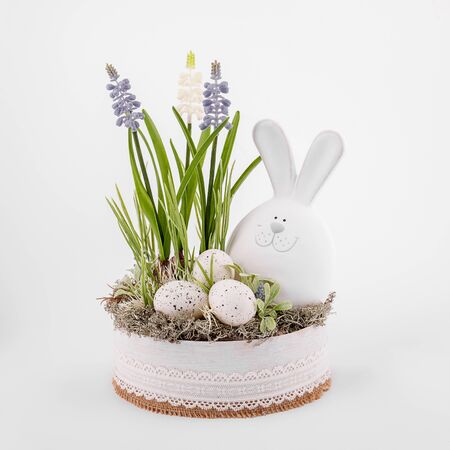 Handmade Easter composition - eggs flowers greens rabbit prepared for Easter, porcelain clay material, on a white backgroundの写真素材