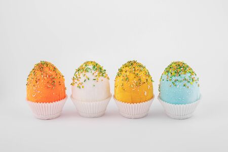handmade decorative easter eggs on a white background with textile and flower ornamentsの写真素材