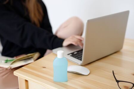 clouse up young girl woman wearing a protective medical mask distributes sanitizer to hands and then...
