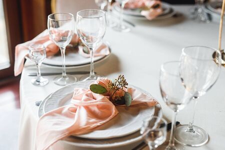 Side view festive table setting with empty wineglasses and two plates. Selebration banquet with...