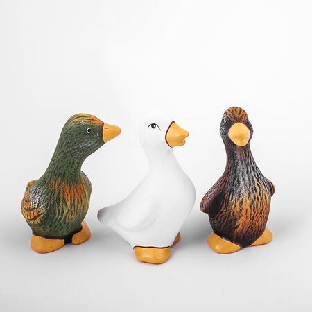 Ceramic ducks look away and look ahead. Isolated three colorful ducks for gardenの写真素材