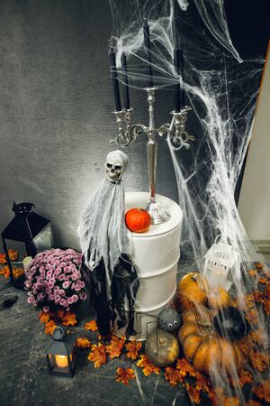 Photozone with pumpkins, candles, scary ghost and cobweb . Creative decorations for party with black wall. Background for halloween celebration.の写真素材