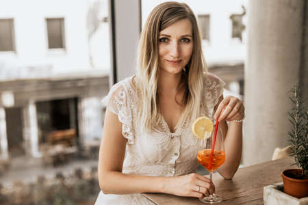 Portrait of a beautiful young woman with a cocktail in a restaurantの写真素材