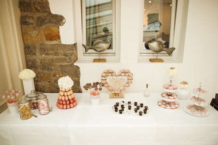 Festive wedding tables with sweets, candies, dessert. Candy bar in pink, brown and beige colorsの写真素材