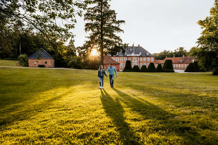 Horizontal photo of romantic couple walking with nature background. Happy man and woman in denim clothingの写真素材