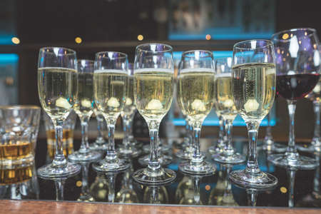 Close up of glasses of champagne on the table with shallow depth of field. Banquet black table with...