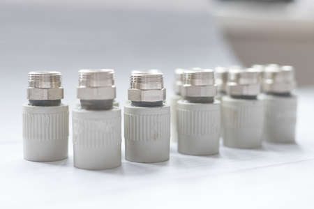 Combined couplings for connecting metal and polypropylene water pipes. Side view nuts in cold colorsの写真素材