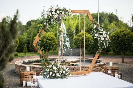 Horizontal photo of wedding ceremony with arch in rustic style with fresh flowersの写真素材