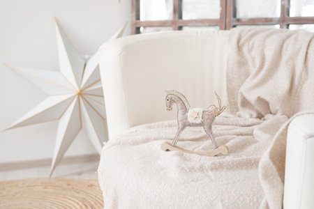 White wooden rocking horse toy on the bed in the living room.の写真素材