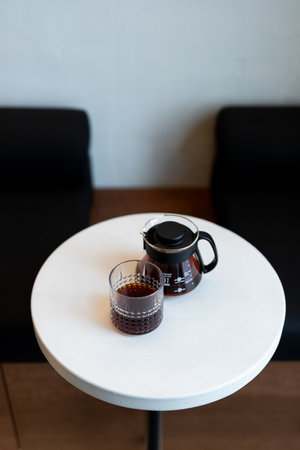 coffee maker and cup of coffee on white table in coffee shop