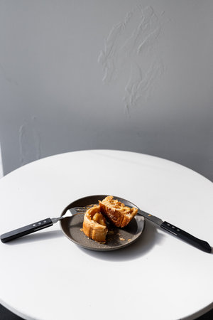 Toast bread on a plate with knife and fork on white tableの写真素材