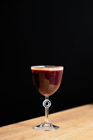 champagne in a glass on a wooden table on a black backgroundの写真素材