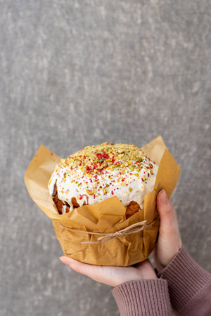 Woman holding a cupcake with icing and sprinkles on gray backgroundの写真素材
