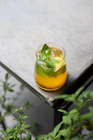 Iced tea with lemon and mint in a glass on the terraceの写真素材
