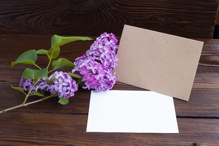 Lilac flowers with white paper on wooden table.の写真素材