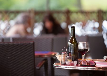 Carafe of red wine with two glasses on the table with dinner dishes.の写真素材