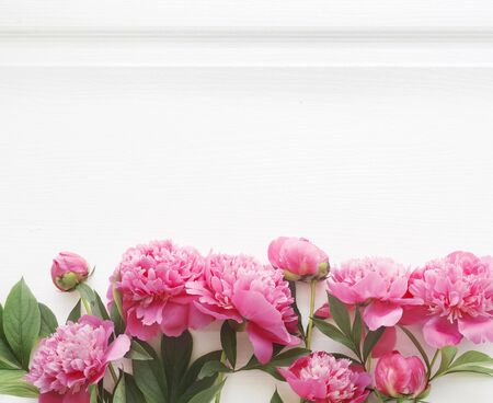 Top view of peony flower border over wooden table. Empty mockup, ready for text place. Minimal interior design, flatlay image.の写真素材