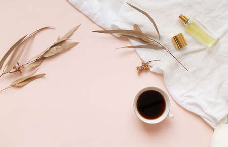 Eucalyptus leaves and a cup of black coffee with a bottle of essence on a light background with empty space.の写真素材