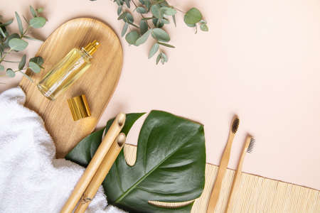 Bamboo toothbrush and leaves of eucalyptus on pink background.の写真素材