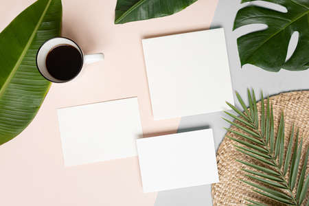 Styled summer wedding desktop stationery mockup. Blank greeting and invitation card. Green tropical leaves with empty space.の写真素材