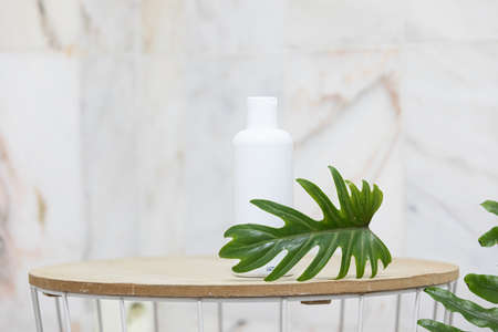 Skin care concept with white bottle and palm leaves on tropical background.の写真素材